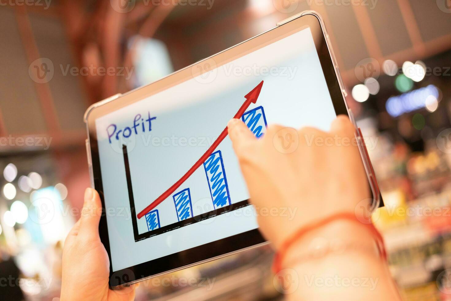 Business growth predication graph in Tablet with blur background of department store. Business successful concept. Concept of growth planning and strategy. photo