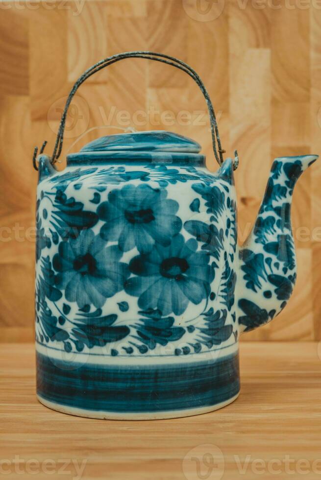 Old Chinese porcelain teapot, with green tea on the wooden photo