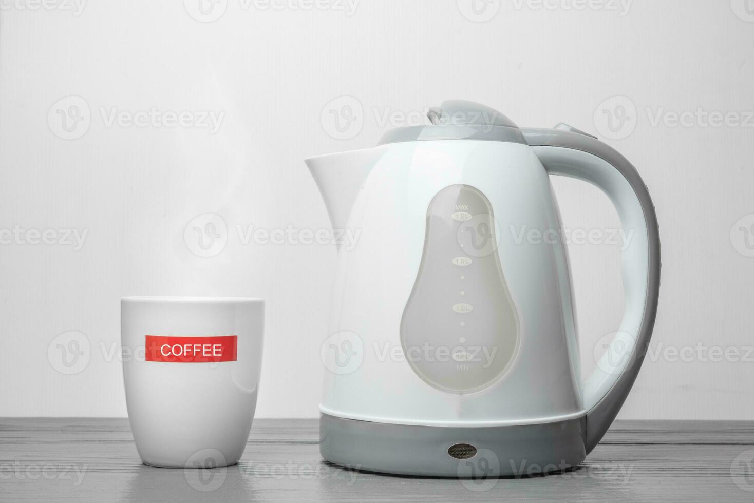 Electric kettle and Coffee cup on wooden table photo