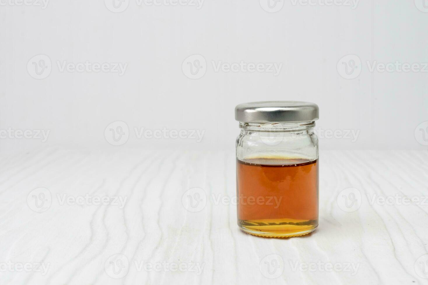 dulce miel en tarro aislado en blanco de madera foto