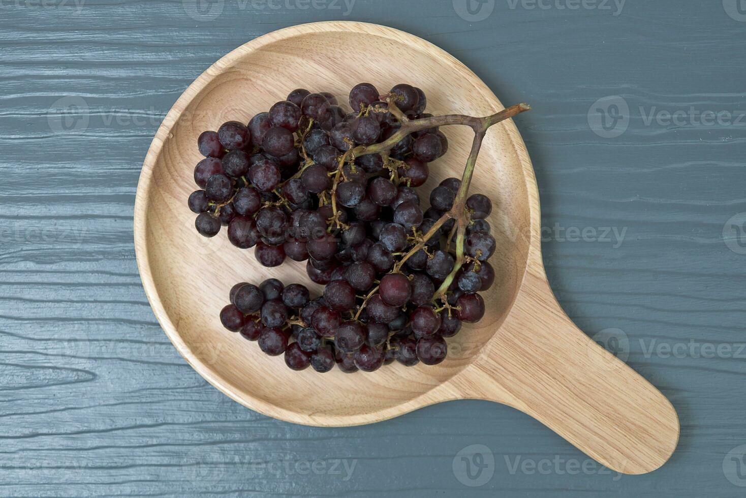 Fresco vistoso sano orgánico sin semillas rojo uvas grumos en madera plato. foto