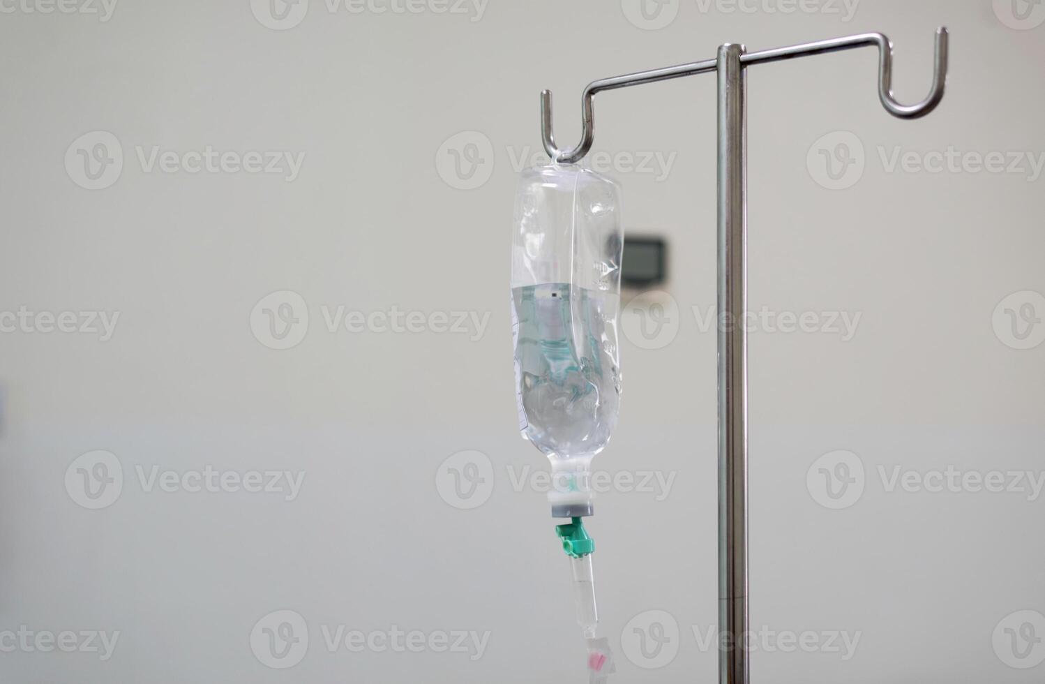 IV bag hanging on a metal pole in the hospital room photo