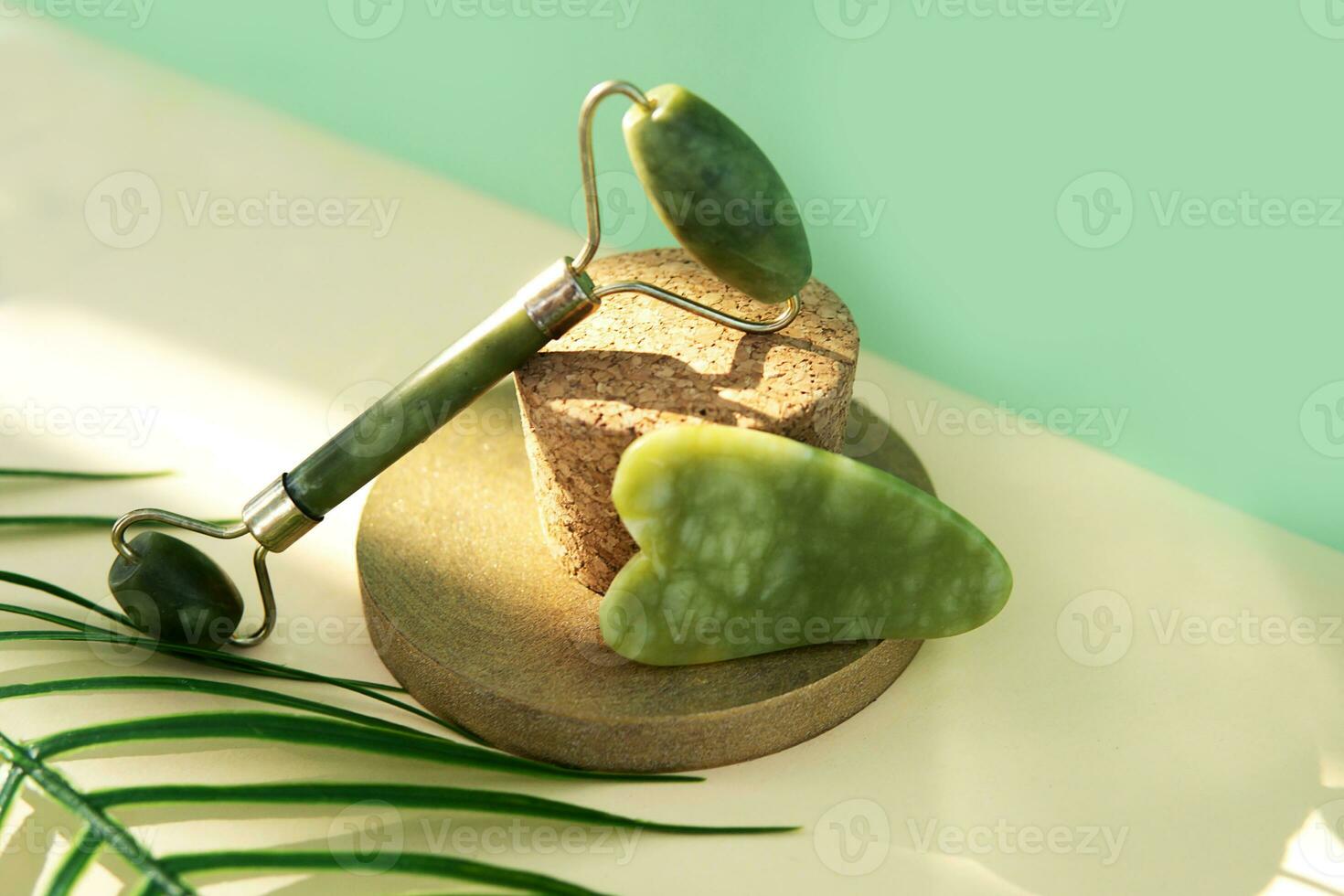 Jade Gua sha scraper and facial massager on beige background. Lifting and toning treatment at home. photo