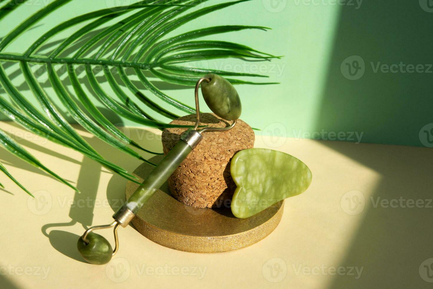 Jade Gua sha scraper and facial massager on beige background. Lifting and toning treatment at home. photo