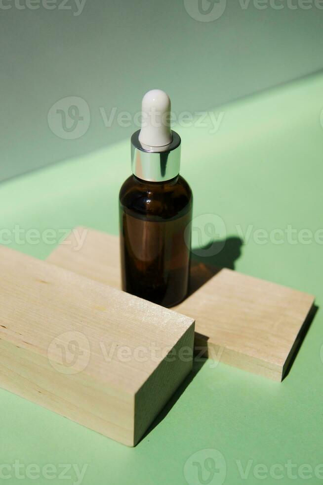 Cosmetic bottle with facial serum on a wooden podium. The concept of zero waste and ecology. photo