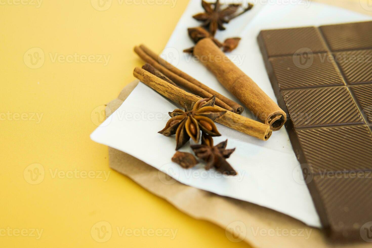 Milk chocolate and cinnamon sticks close-up. Photos in warm colors. Sweetness. World chocolate day. Macro.