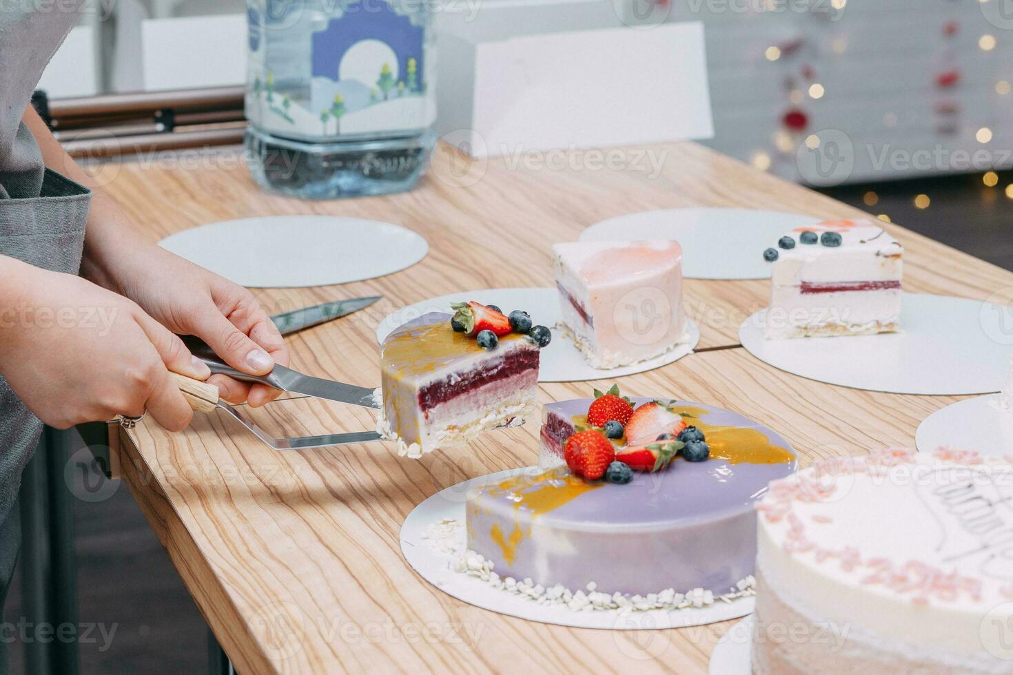 Cutting a chocolate mousse cake on the table. Preparation of mousse cakes at a culinary master class. Cooking at home, homemade food photo