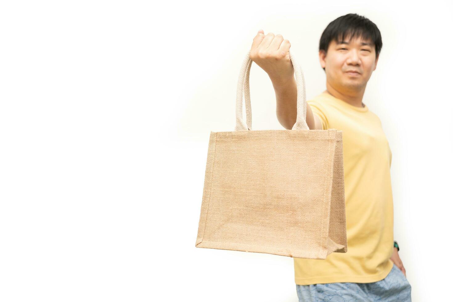 Man holding jute bag or sack bag on white background. Reusable shopping bag. Plastic free. Eco friendly concept. Sack bag for reusable shopping lifestyles, ecology business concept. photo
