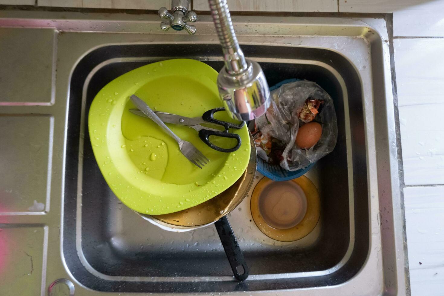 Dishwashing with piles of dirty dishes and food waste photo