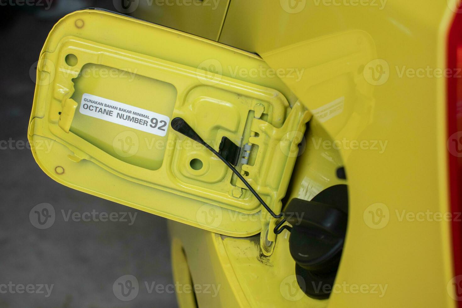 selective focus on the yellow car fuel tank cover with a warning using octane fuel number 92. soft focus photo