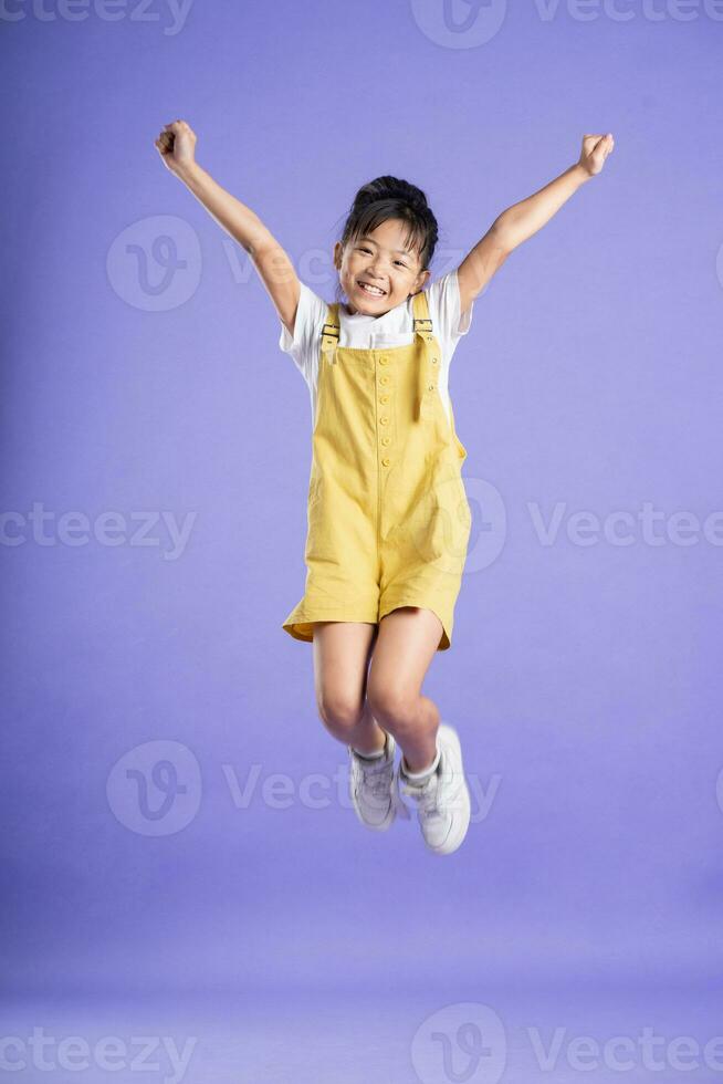 linda asiático bebé niña posando en púrpura antecedentes foto