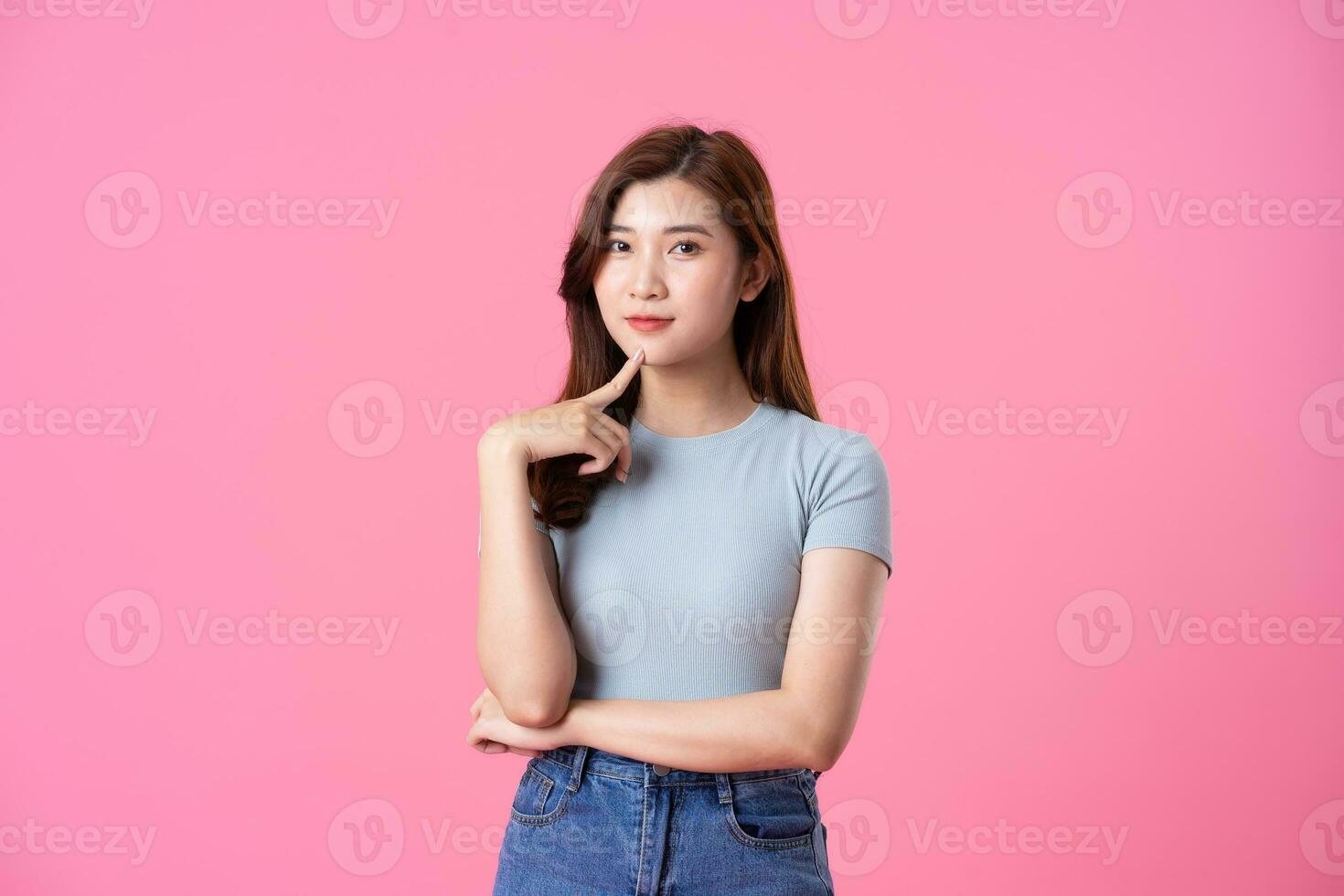 portrait of young asian girl posing on pink background photo