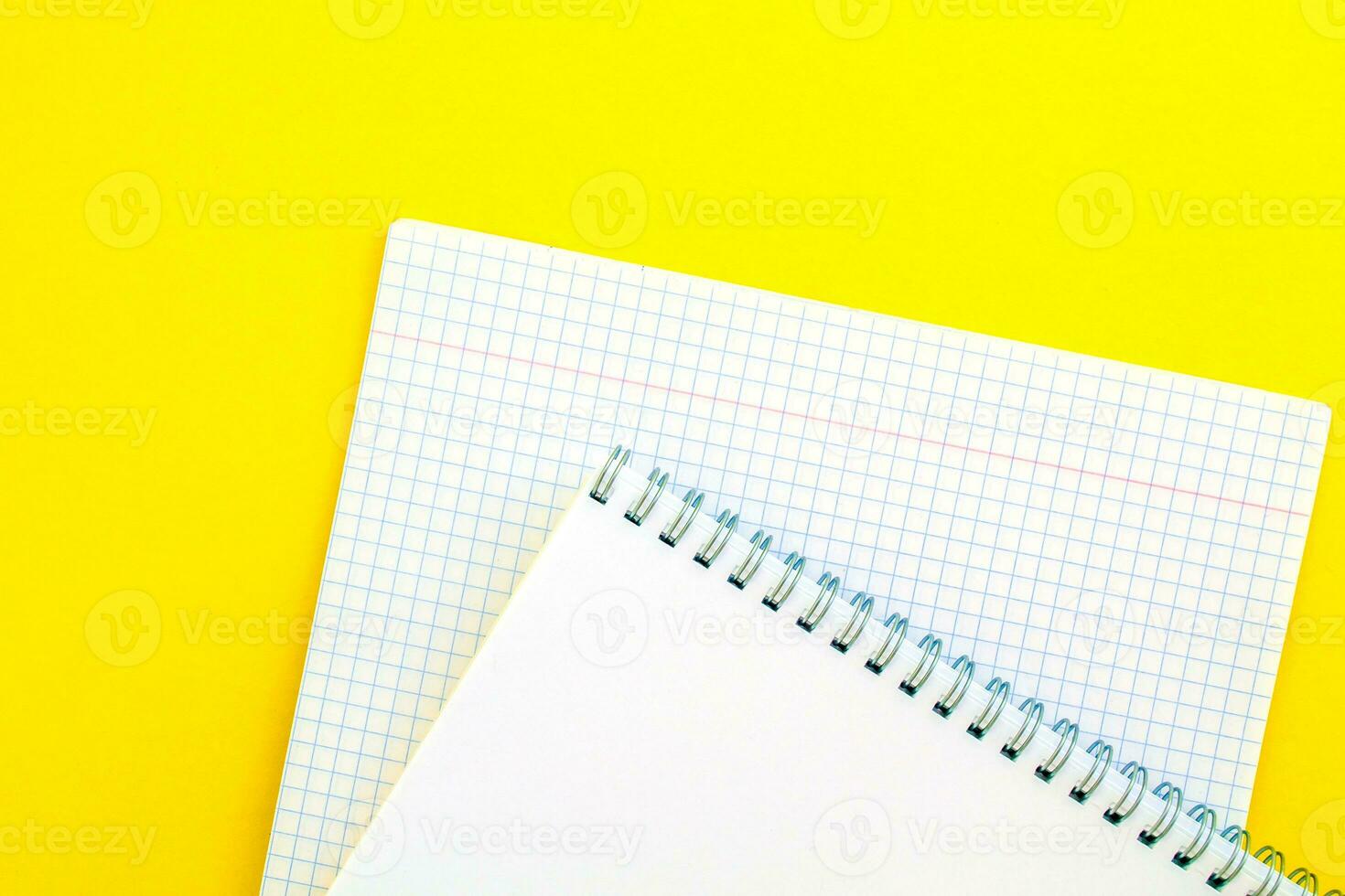 blanco bloc y cuaderno en un jaula en un amarillo antecedentes. foto