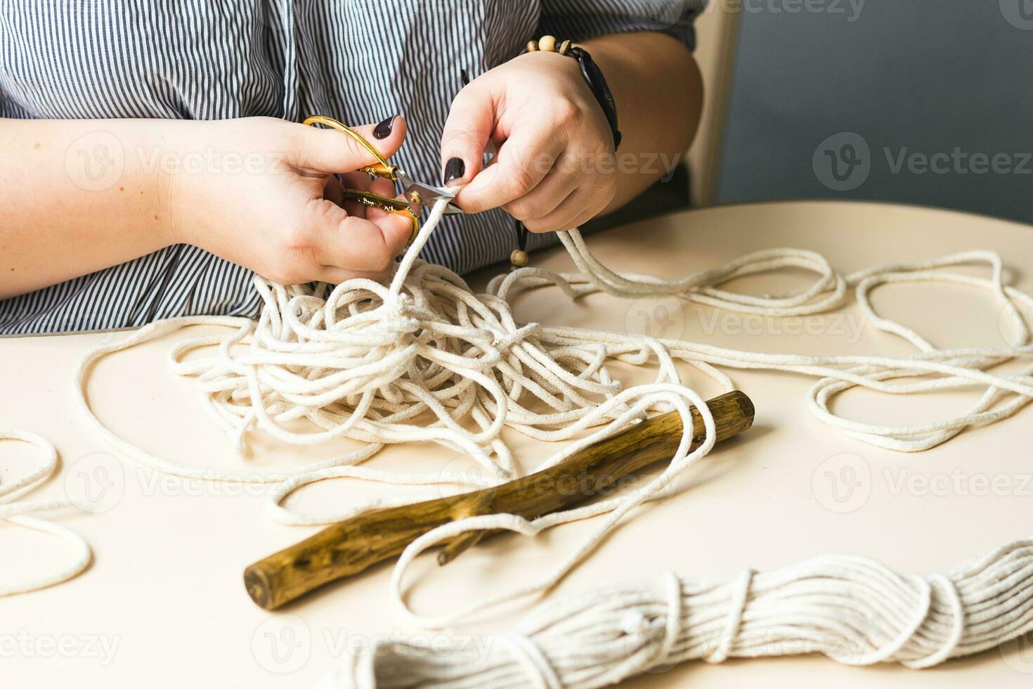 Female hands weave macrame the home workshop. Boho lifestyle. Hobby hobby concept. Selective focus horizontal frame. photo