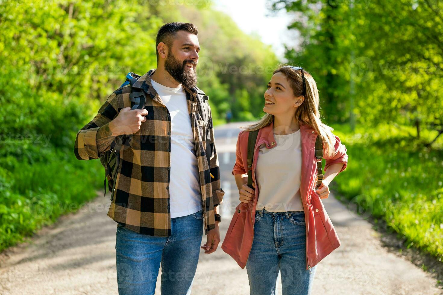 Happy couple hiking in nature on sunny day. Couple enjoying their vacation. photo