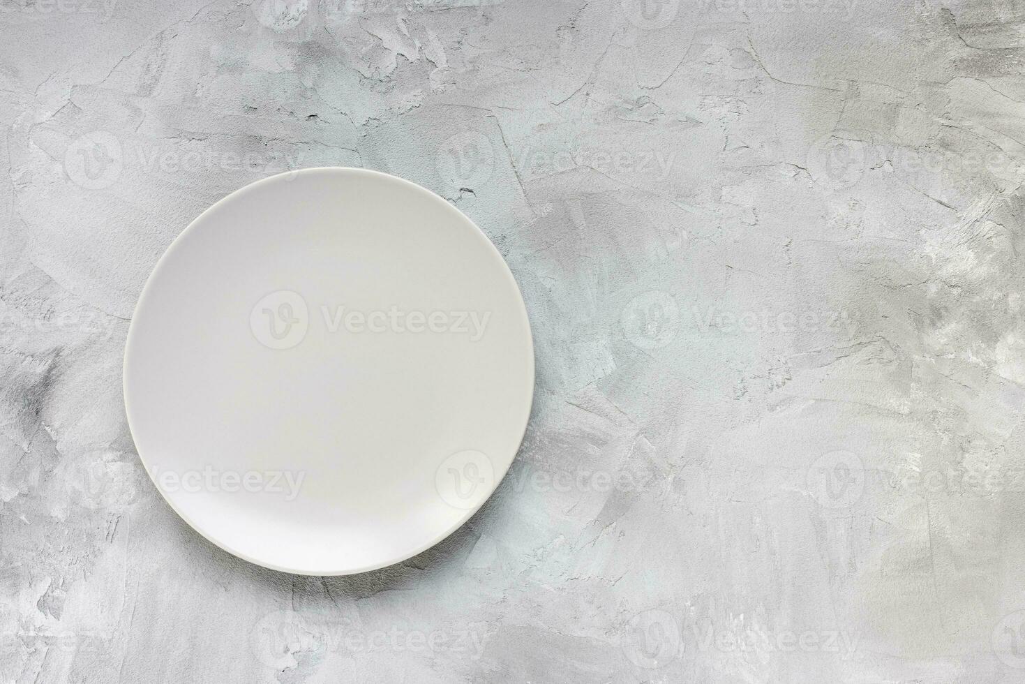 Empty plate on rough gray minimalistic background photo