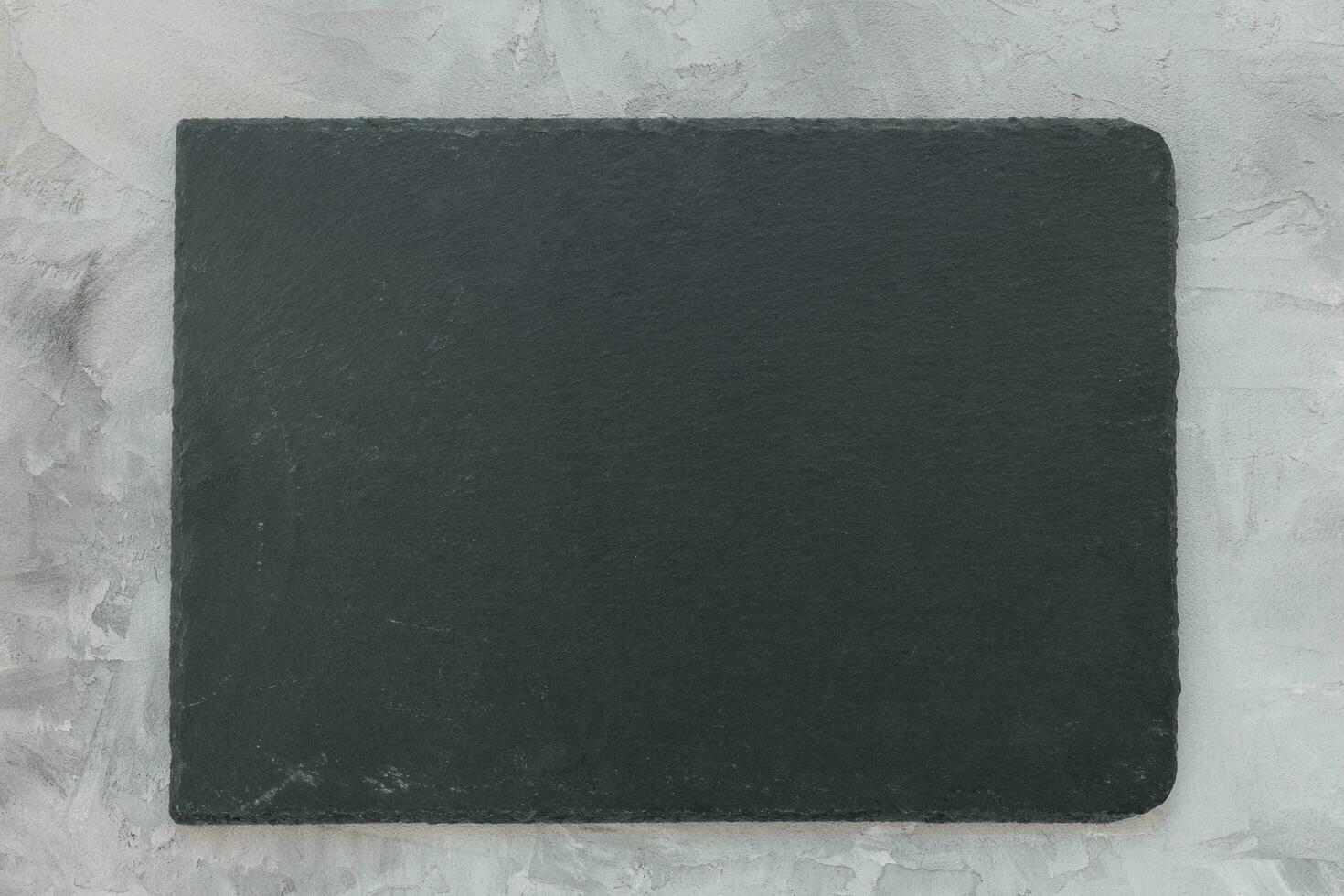 Black slate plate board on gray background photo