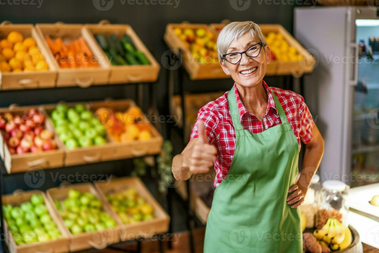 maduro mujer trabajos en frutas y vegetales tienda. retrato de pequeño negocio supermercado dueño. foto