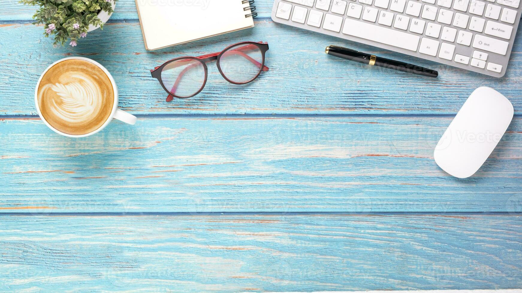 Office desk workplace with keyboard, mouse, pen, eyeglass, notebook and cup of coffee, Top view flat lay with copy space. photo