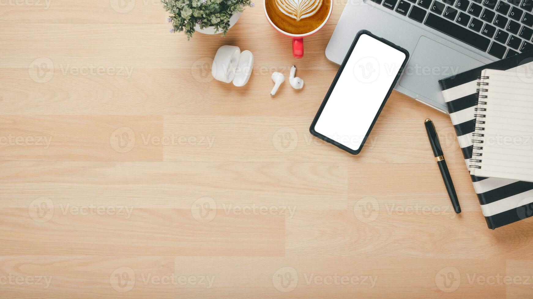 Wooden desk workplace with blank screen smart phone, laptop, earphone, pen, notebook and cup of coffee, Top view flat lay with copy space. photo