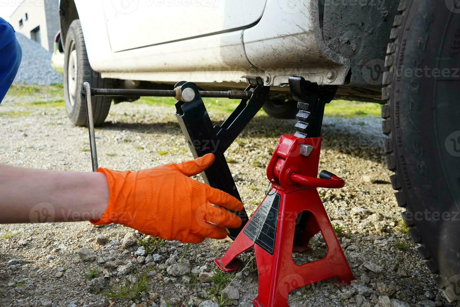 Car lifted on jack. Mechanic lifting up the car with car jack. Tire change. Mechanic changing tire in the car. photo