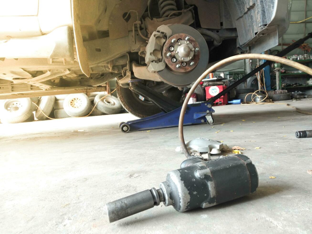 Old air wrench on the floor  Car front disc brakes, maintenance, problem solving photo