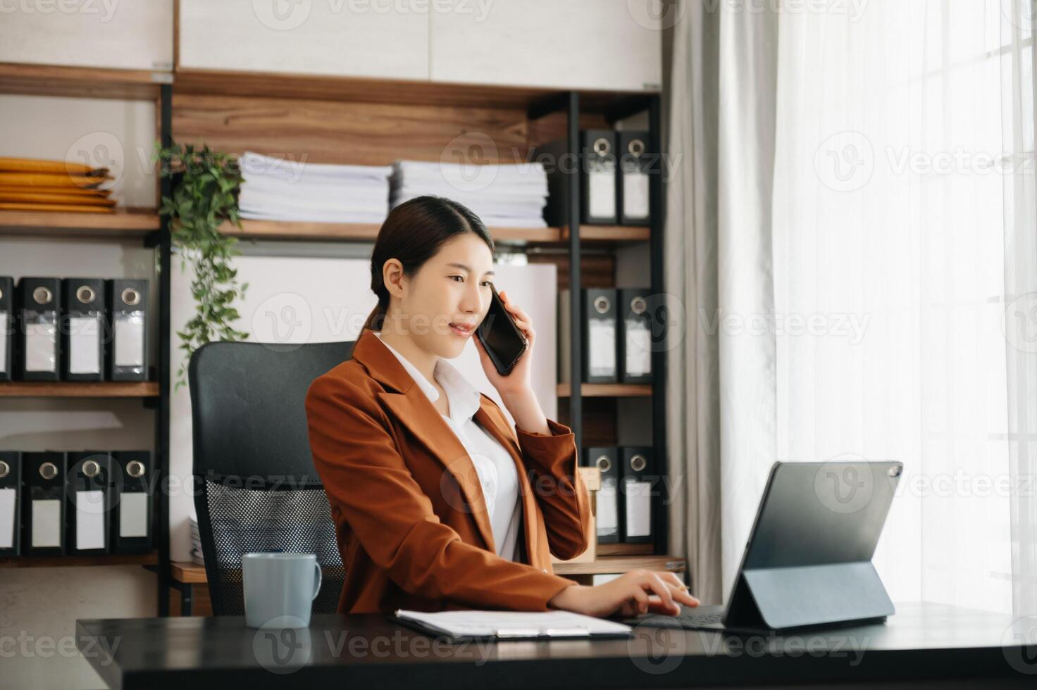 Business woman using tablet and laptop for doing math finance on an office desk, tax, report, accounting, statistics, and analytical research concept in office photo