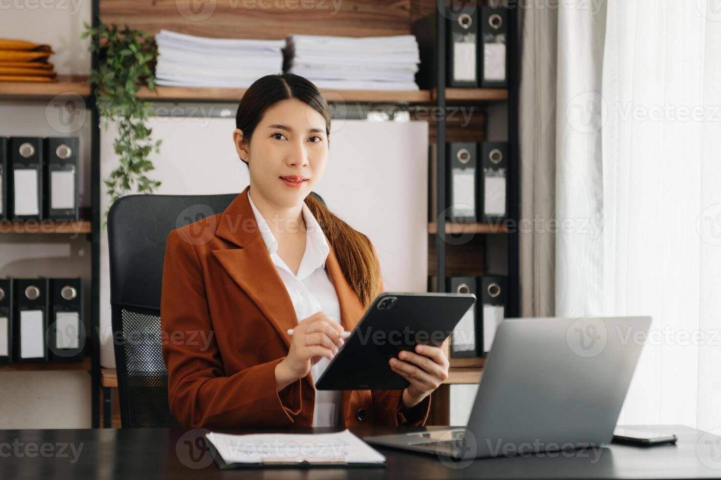 Business woman using tablet and laptop for doing math finance on an office desk, tax, report, accounting, statistics, and analytical research concept in office photo