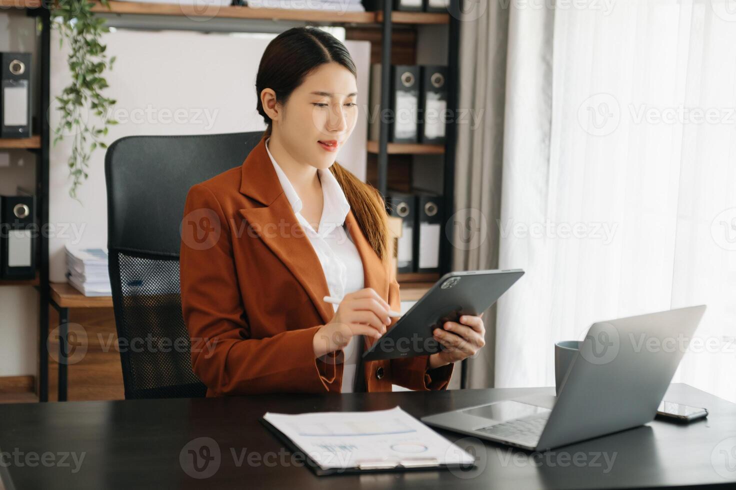Business woman using tablet and laptop for doing math finance on an office desk, tax, report, accounting, statistics, and analytical research concept in office photo