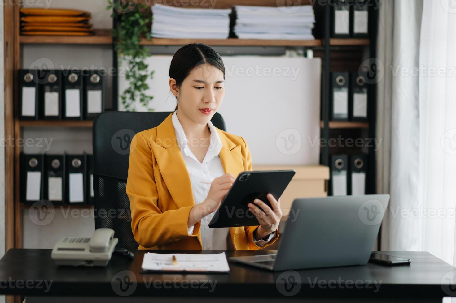 Business woman using tablet and laptop for doing math finance on an office desk, tax, report, accounting, statistics, and analytical research concept in office photo