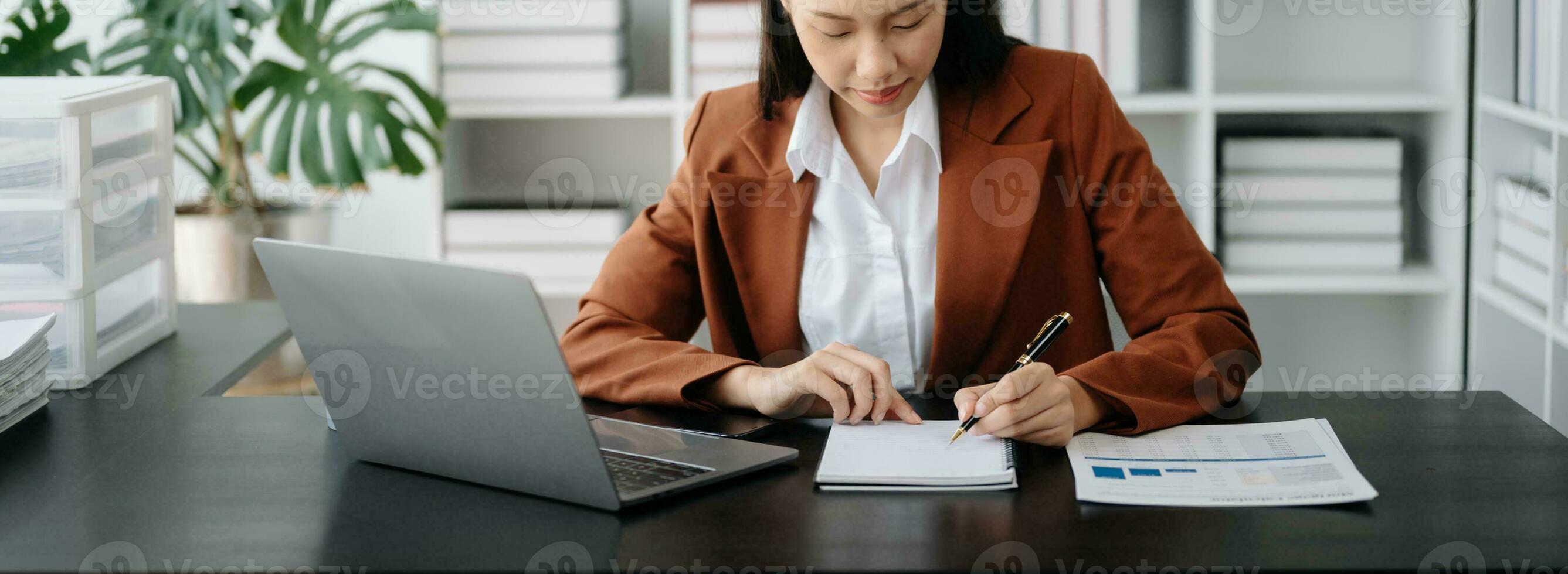 negocio mujer sentado frente tableta ,computadora portátil computadora con financiero gráficos y Estadísticas en monitor. foto