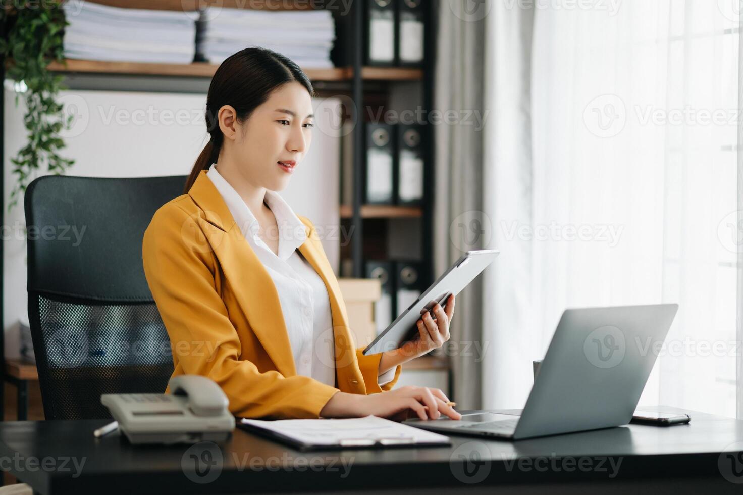 Business woman using tablet and laptop for doing math finance on an office desk, tax, report, accounting, statistics, and analytical research concept in office photo
