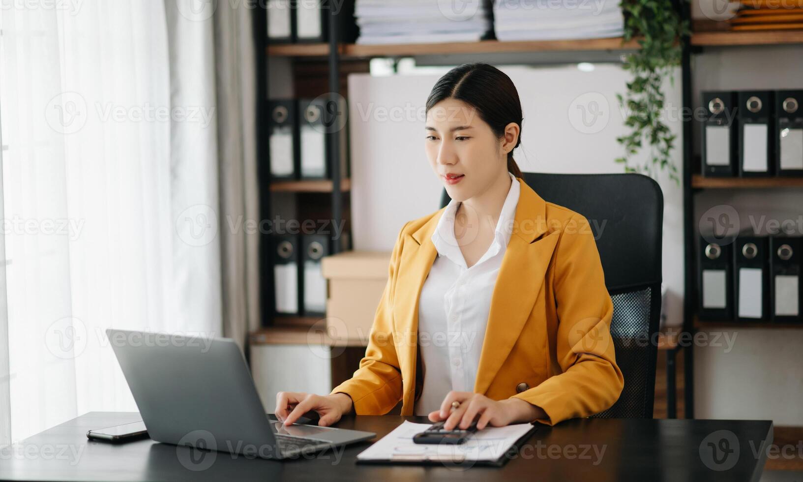 Business woman using tablet and laptop for doing math finance on an office desk, tax, report, accounting, statistics, and analytical research concept in office photo