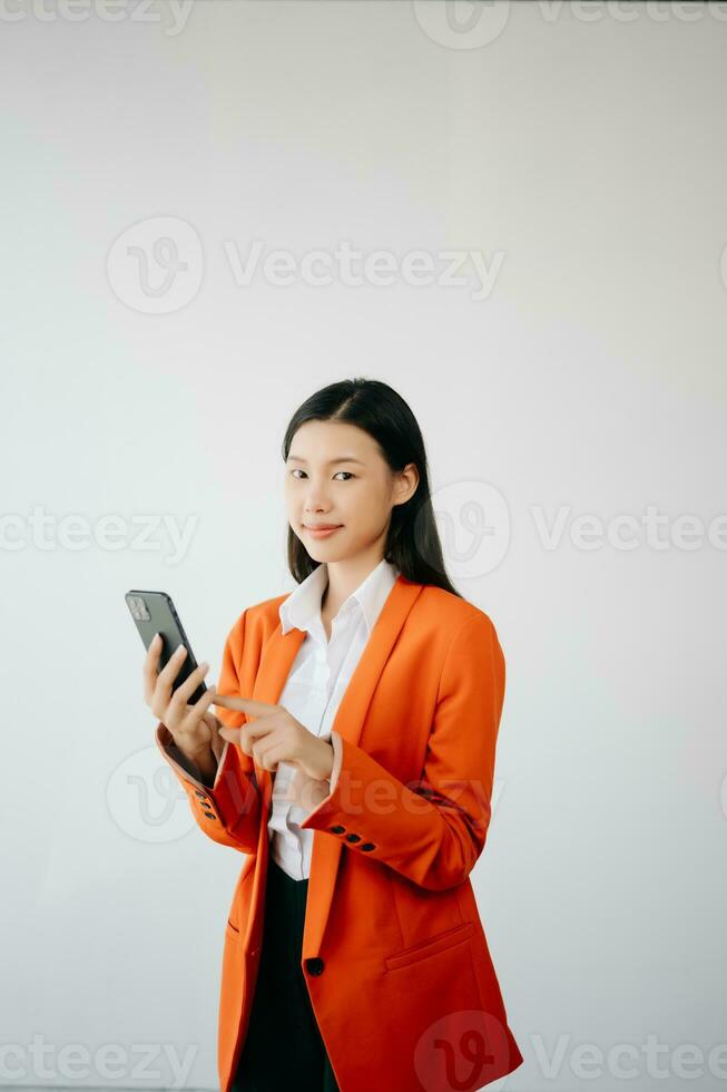 Portrait photo of young beautiful Asian woman feeling happy and holding smart phone, tablet and laptop with black empty screen on white background product presenting concept.