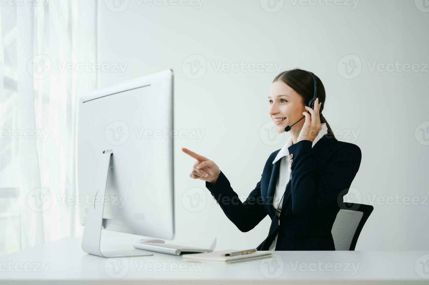 Serious call center operator in wireless headset talking with customer, woman in headphones with microphone consulting client on phone in customer support service in office center photo