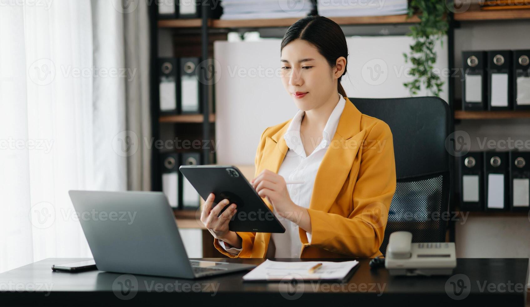 Business woman using tablet and laptop for doing math finance on an office desk, tax, report, accounting, statistics, and analytical research concept in office photo