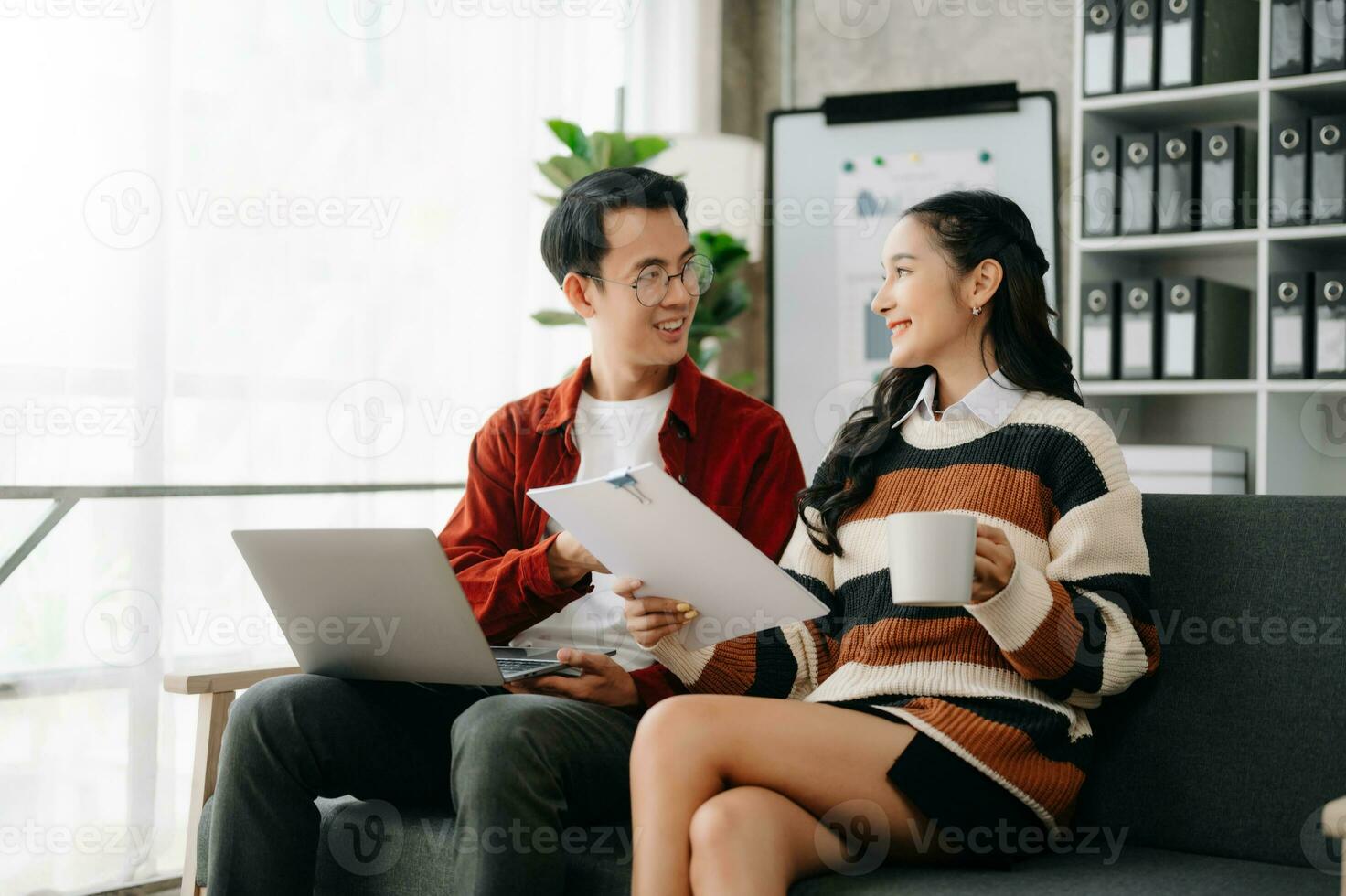 Businesswoman leading team meeting and using tablet and laptop computer with financial in coworking office photo