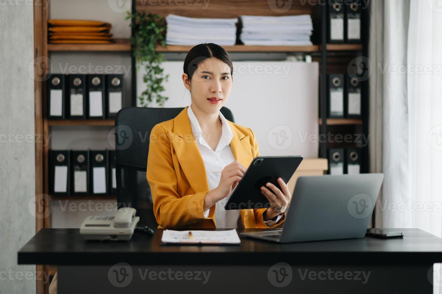 Business woman using tablet and laptop for doing math finance on an office desk, tax, report, accounting, statistics, and analytical research concept in office photo