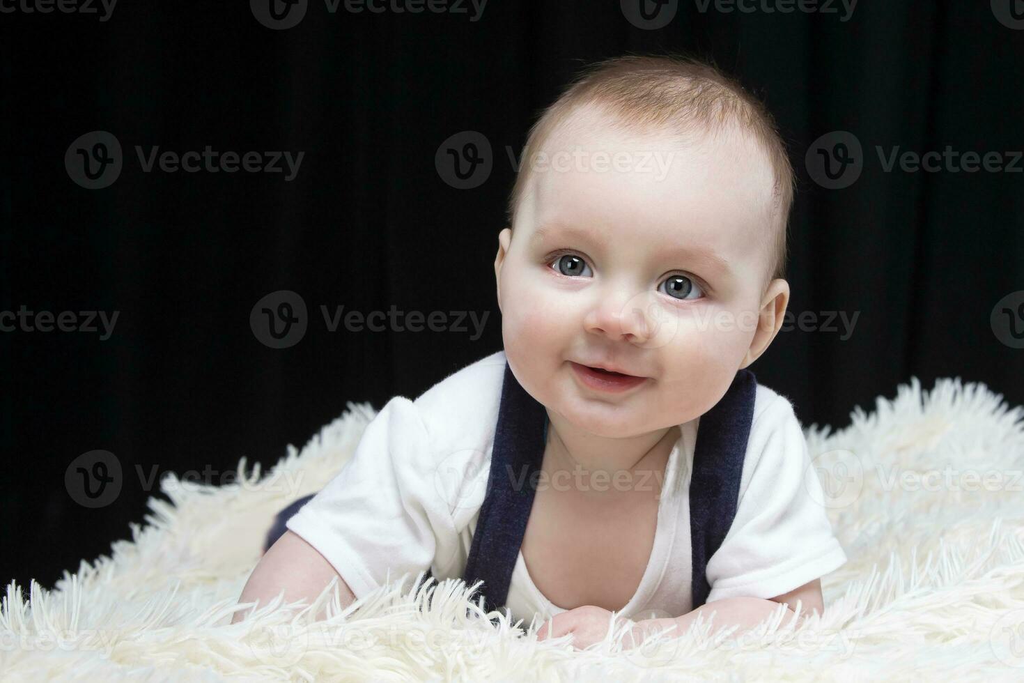 hermosa bebé chico sonrisas y mira dentro el cámara. bebé a cuatro meses viejo. un gracioso niño. foto