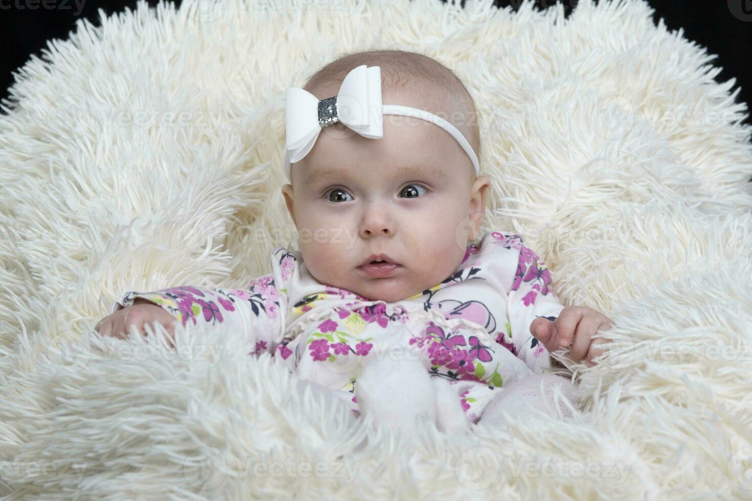 Beautiful baby in a fur blanket. The girl is four months old. Children under one year old. photo