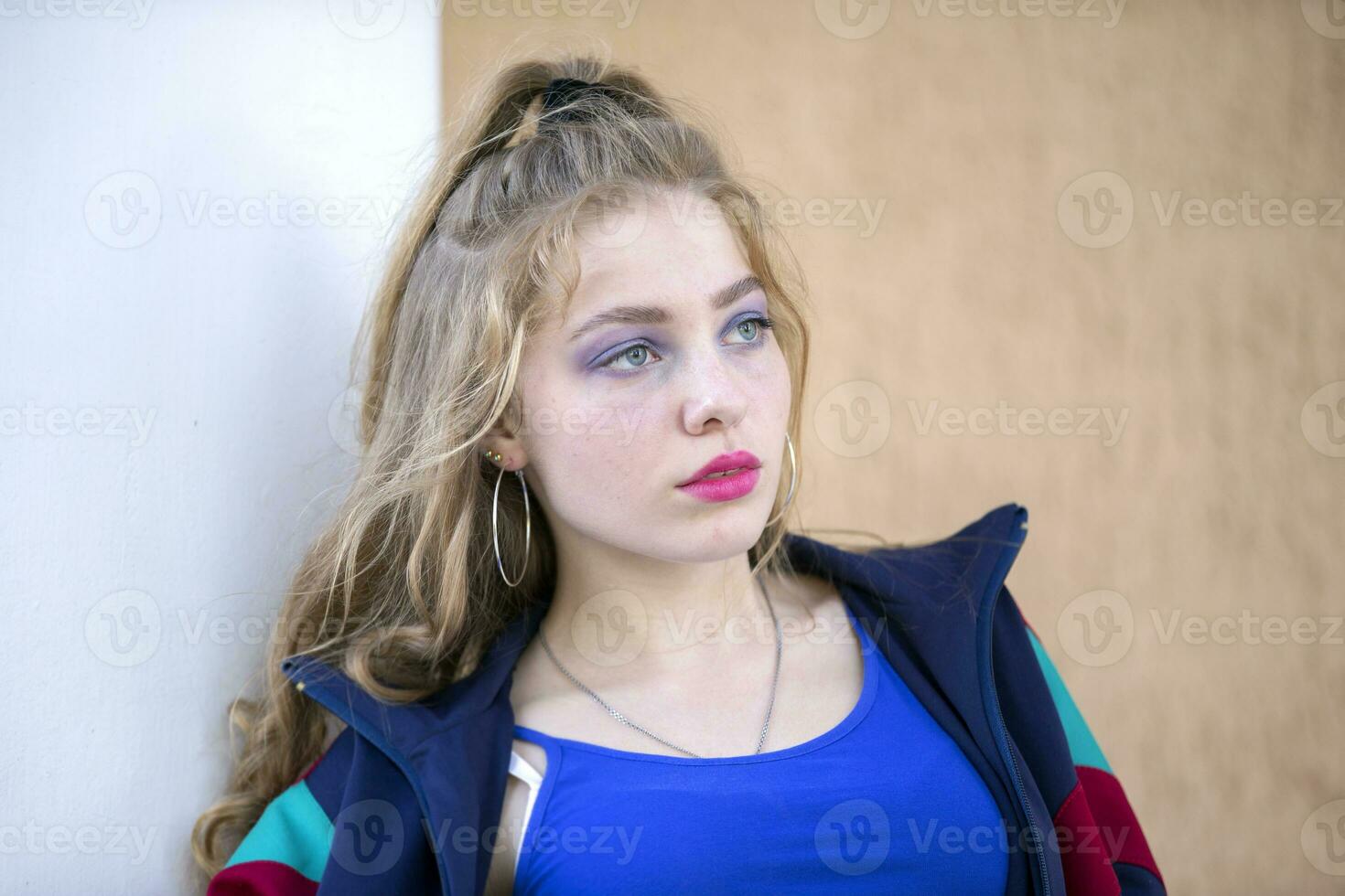Portrait of a funny brunette girl with bright makeup in a sports trowel. Girl in the style of the eighties. photo