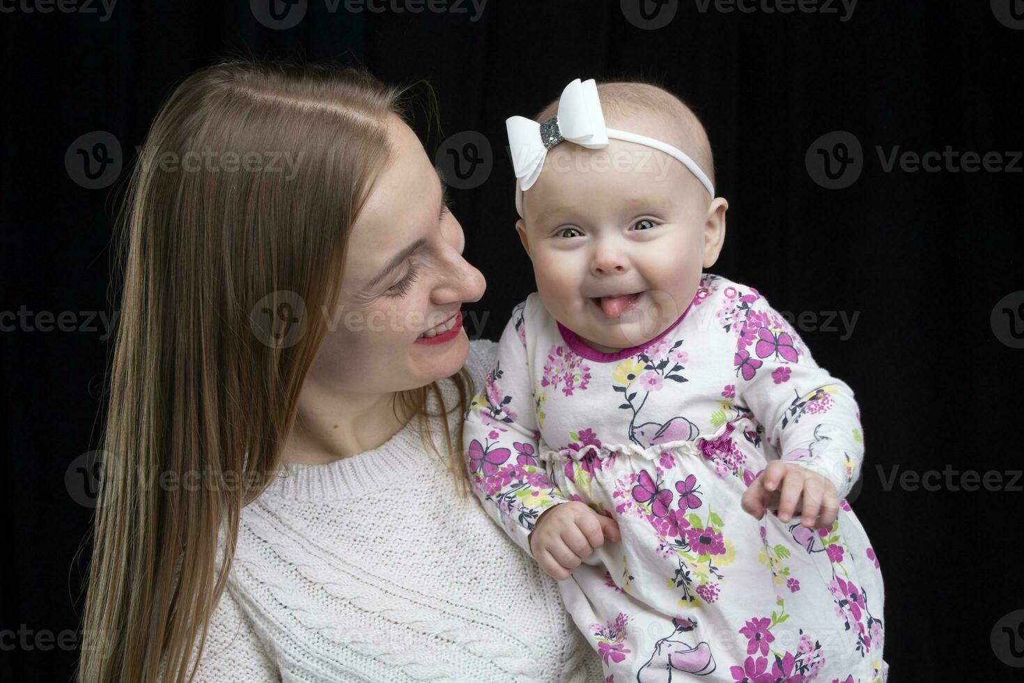 Mom holds a little happy daughter in her arms. Motherhood. photo