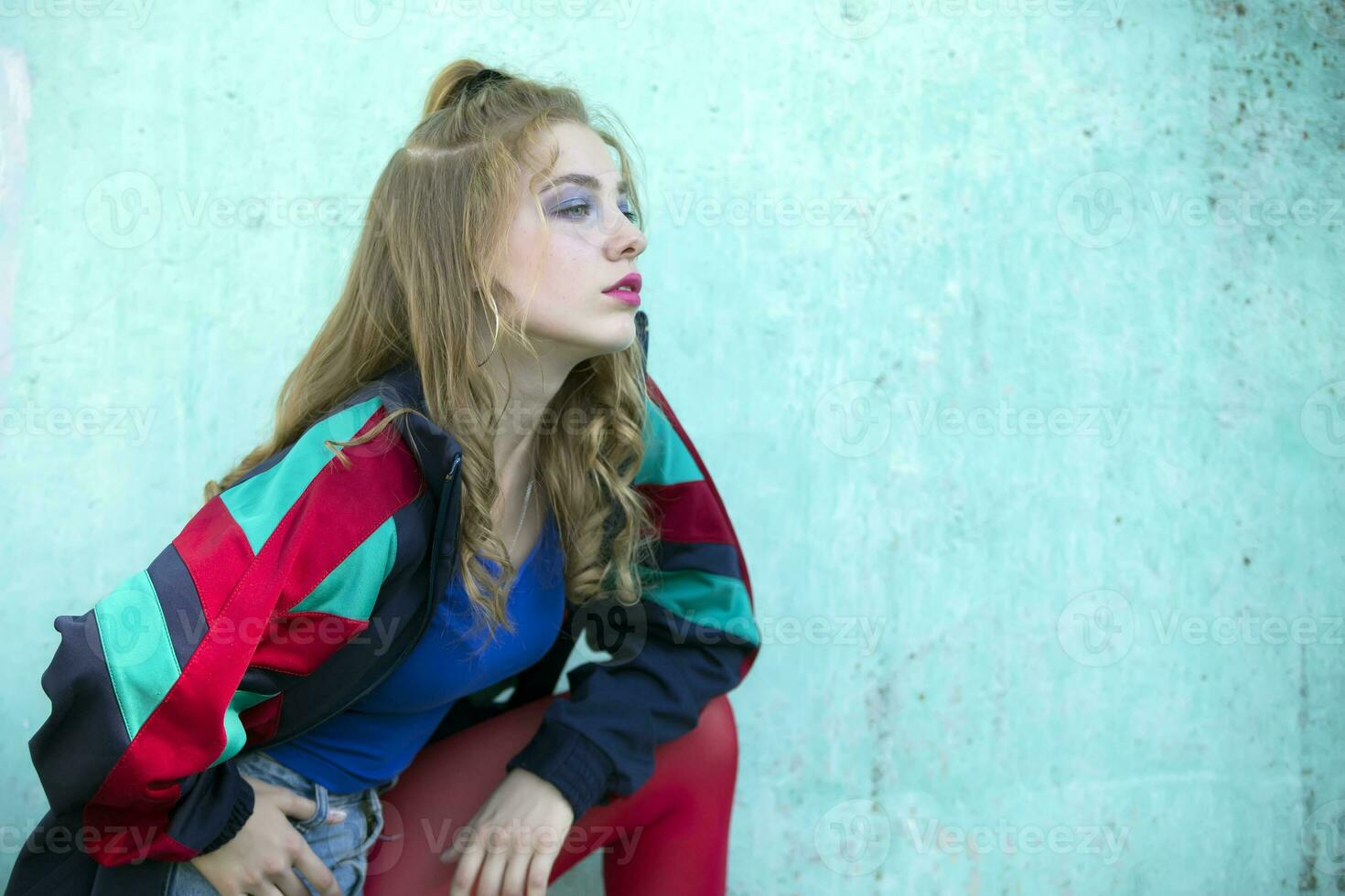 The girl is dressed in the style of the nineties. A beautiful bright woman in red tights and a sports trowel. photo