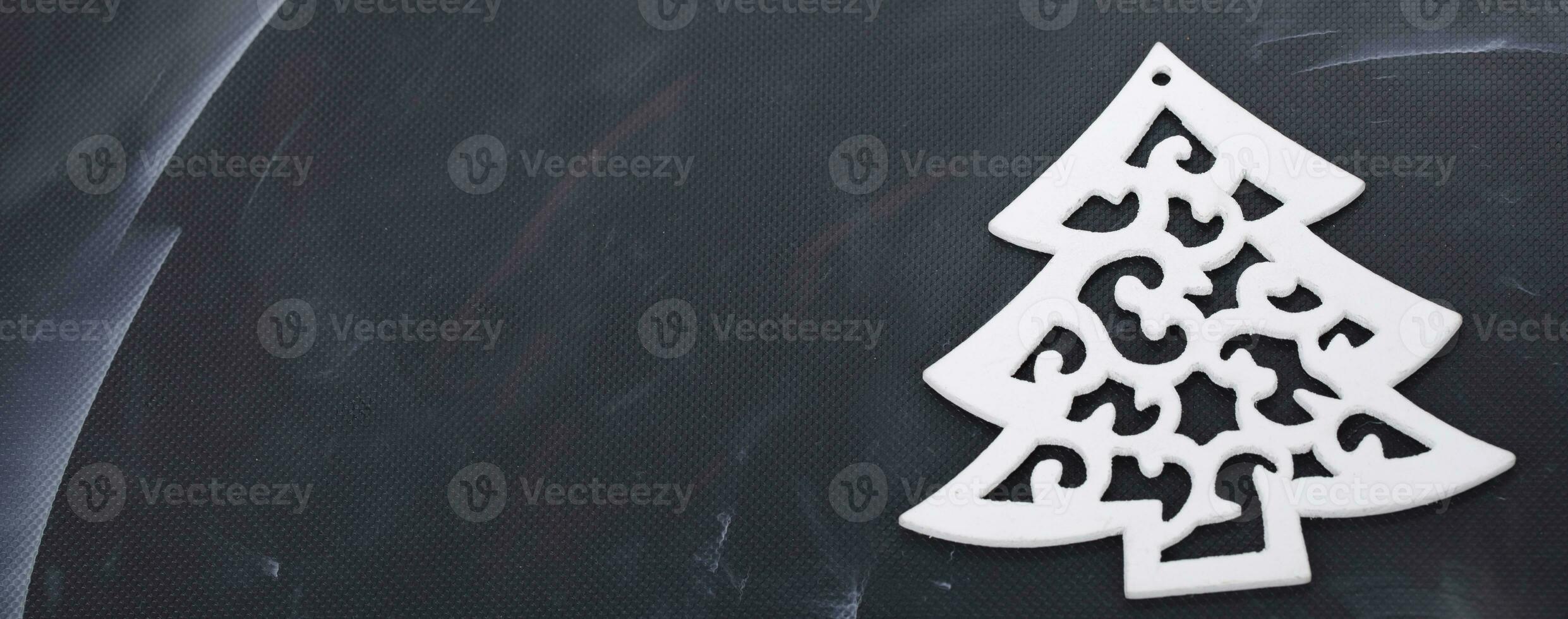 Wooden toy tree on a black background.Christmas background. photo