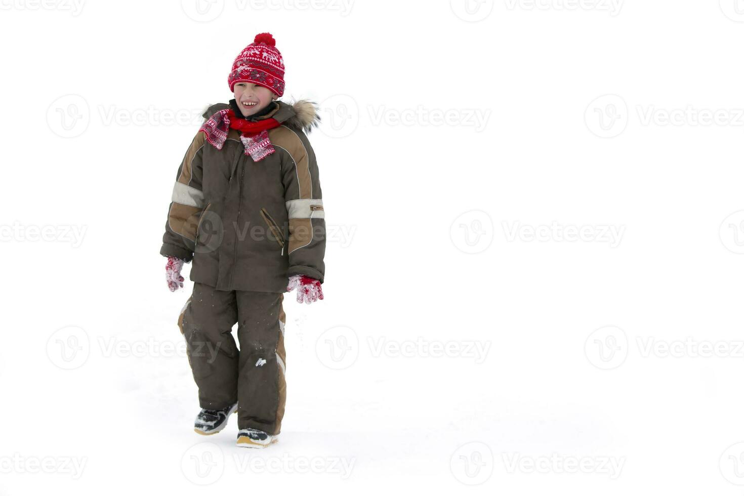 Child in winter. A boy in winter clothes walks in the snow. photo