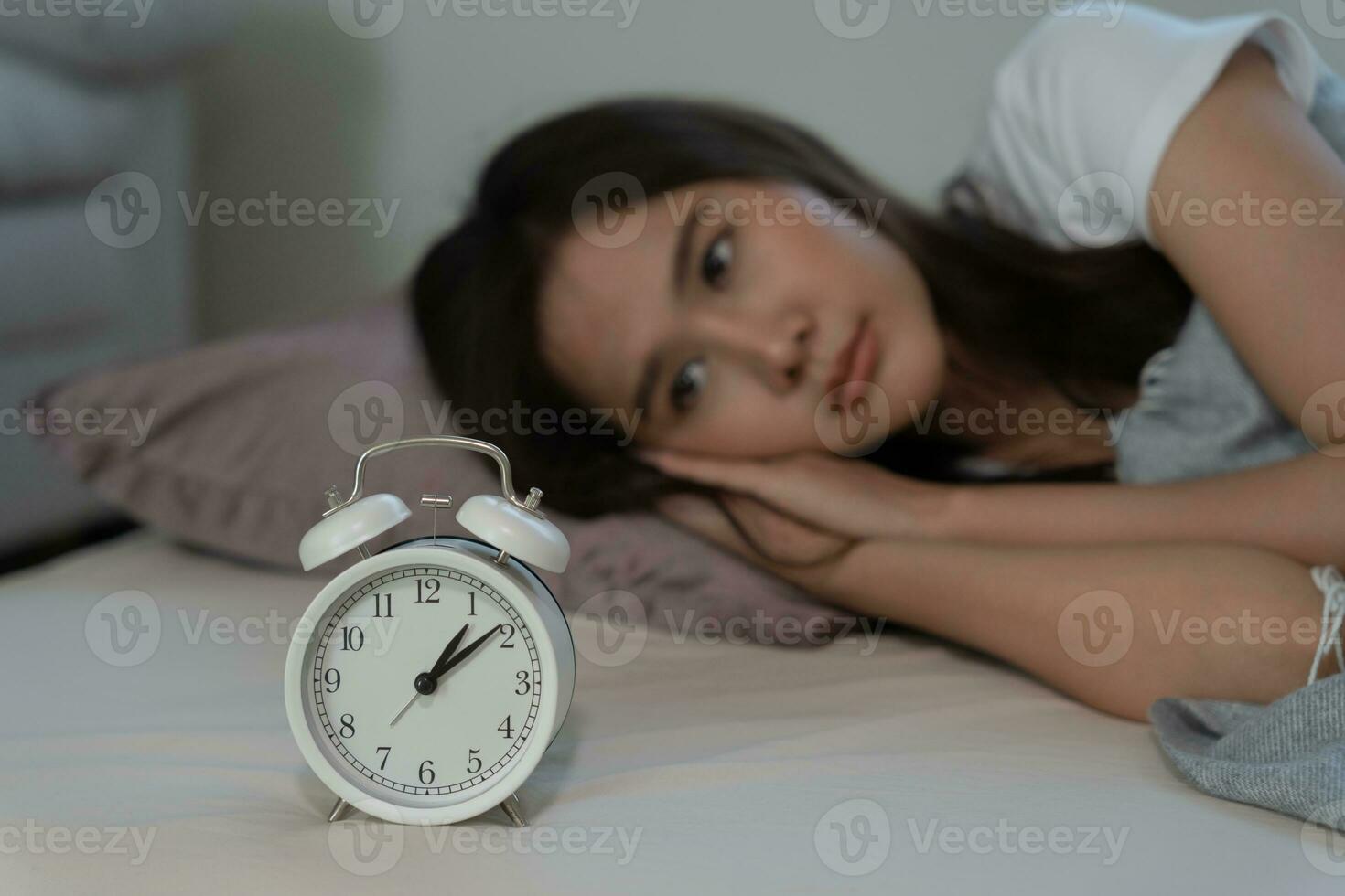 asiático mujer en cama tarde molesto a dormir sufrimiento insomnio, insomne o asustado en un pesadilla, mirando triste preocupado y estresado. cansado y dolor de cabeza o migraña despertar arriba en el medio de el noche. foto