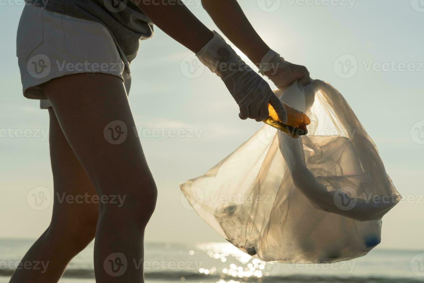 Save water. Volunteer pick up trash garbage at the beach and plastic bottles are difficult decompose prevent harm aquatic life. Earth, Environment, Greening planet, reduce global warming, Save world photo