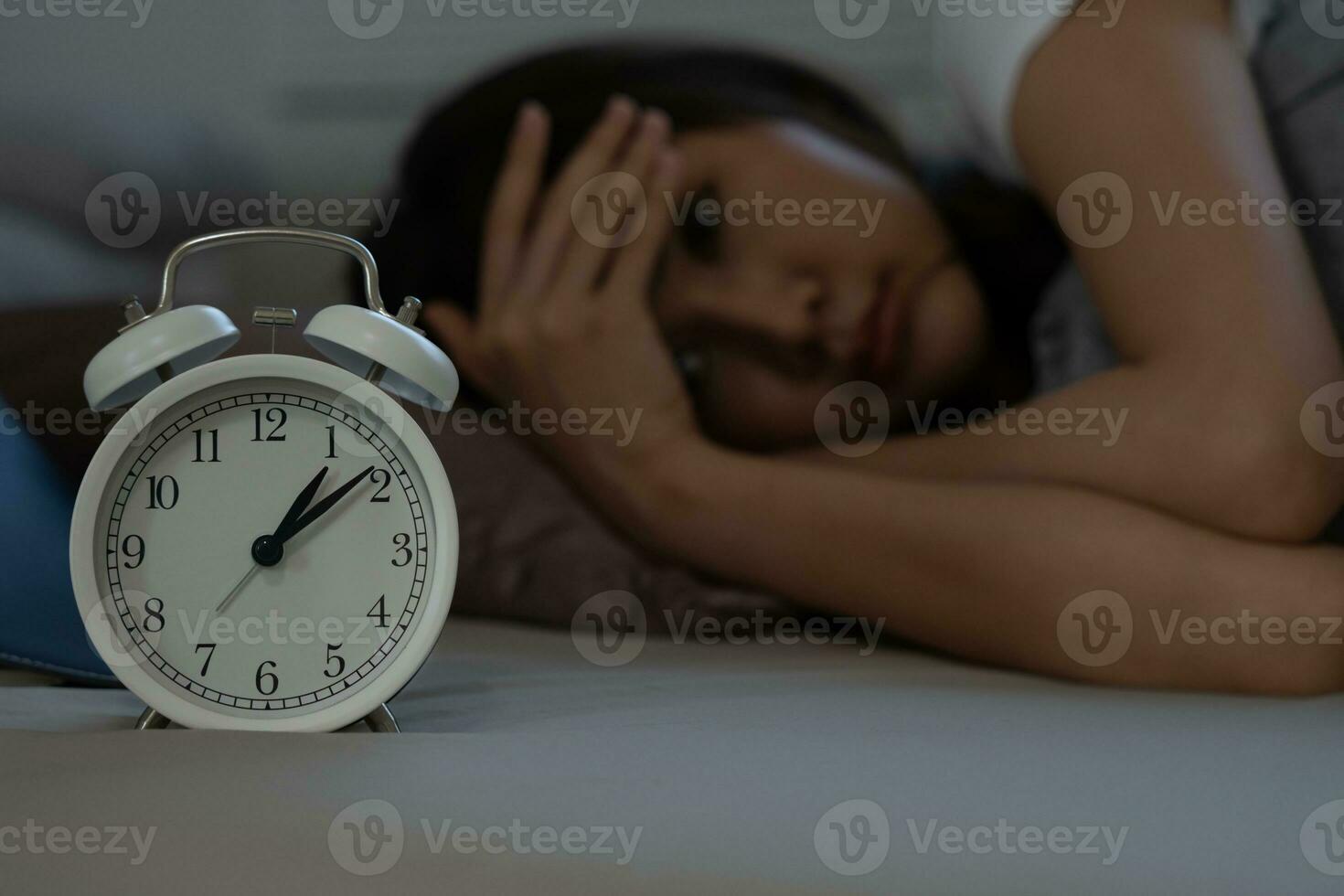 asiático mujer en cama tarde molesto a dormir sufrimiento insomnio, insomne o asustado en un pesadilla, mirando triste preocupado y estresado. cansado y dolor de cabeza o migraña despertar arriba en el medio de el noche. foto