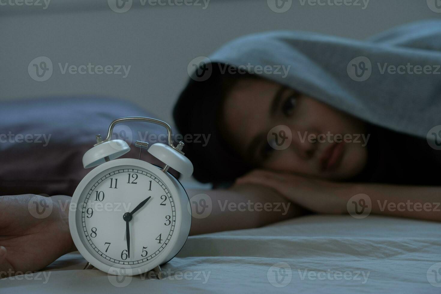 asiático mujer en cama tarde molesto a dormir sufrimiento insomnio, insomne o asustado en un pesadilla, mirando triste preocupado y estresado. cansado y dolor de cabeza o migraña despertar arriba en el medio de el noche. foto