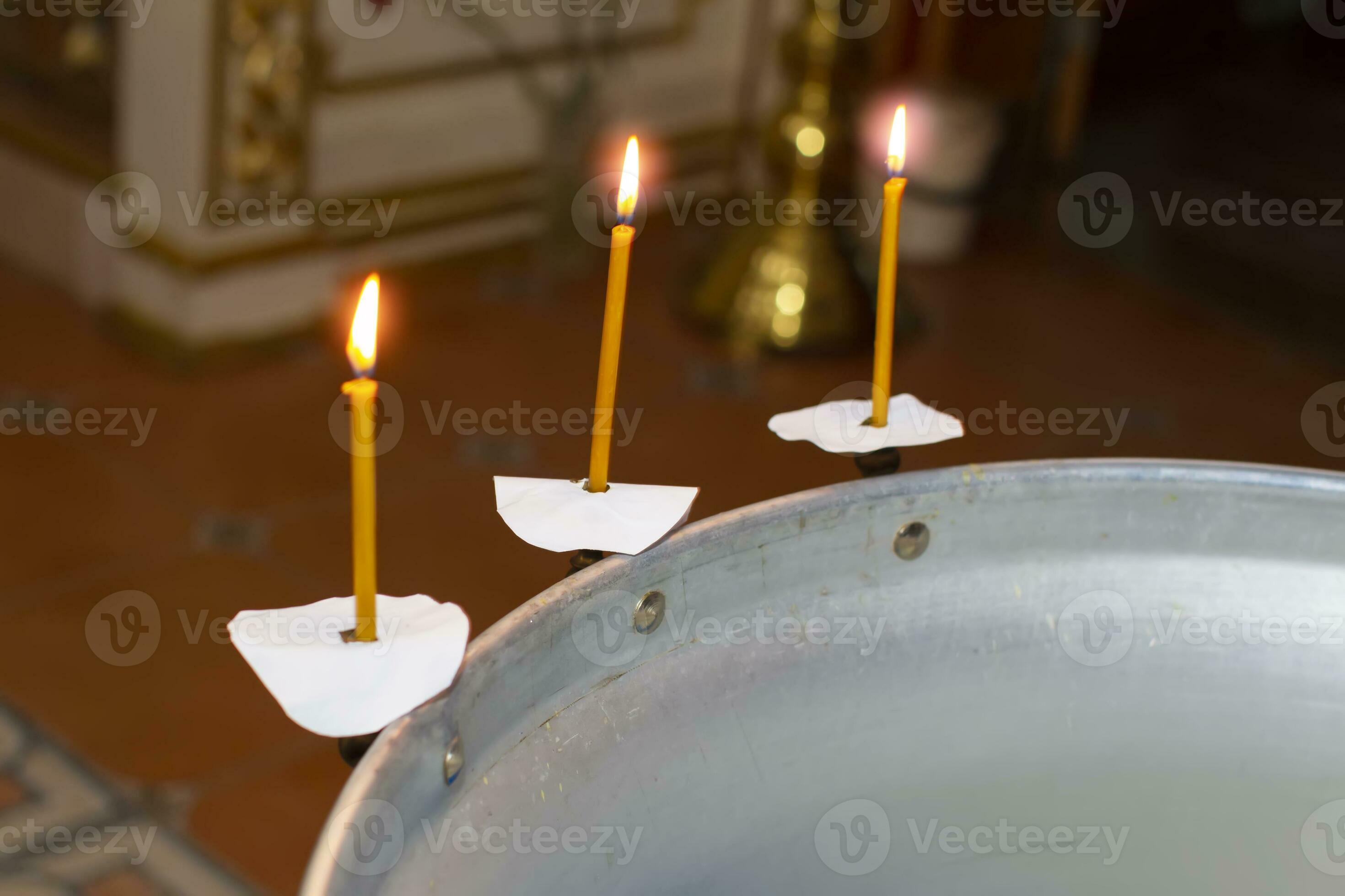 Part of the baptismal font for a child with lit candles. Church